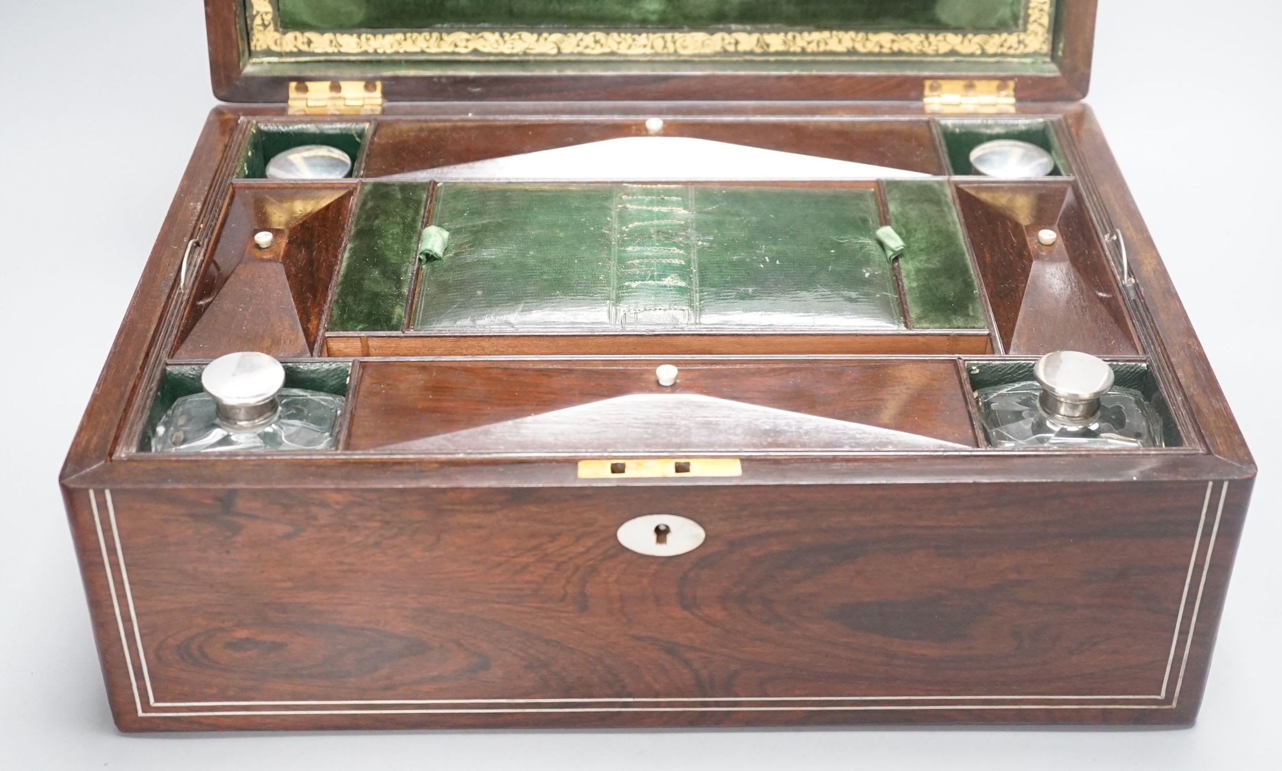 A Victorian rosewood sewing box containing white metal lidded glass bottles, box 37 cms wide x 15 cms high.